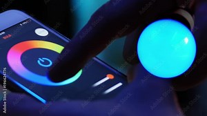 Smart home lighting technology, controlling color of a bulb and scheduling time with a smart phone. Remote controlling light with a phone app. 4k Video