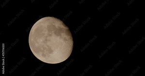 Time lapse of the moon rising with the lunar surface visible in close-up.