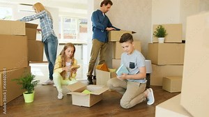 Happy family opening box and decorating the living room while moving to the new house.