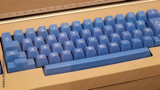 Slow panning macro closeup of a simple retro vintage computer keyboard with blue keycaps on a beige case, Nordic QWERTY layout and special letters, classic old PC terminal input device, no people