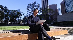 Asian businessman operating a tablet in an American business district