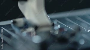 Sewing needle in slow motion. Close up of sewing machine needle work process. Macro. Sewing needle working. Manufacturing equipment at textile factory. Closeup. Textile industry