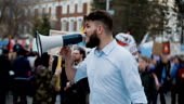 Young adult angry man goes and shouts in a megaphone on strike....