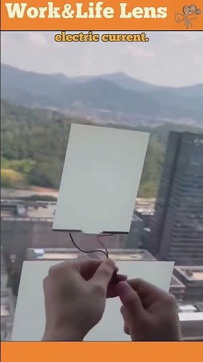 A woman applies electrochromic film to a window, then adds current to make it crystal clear.