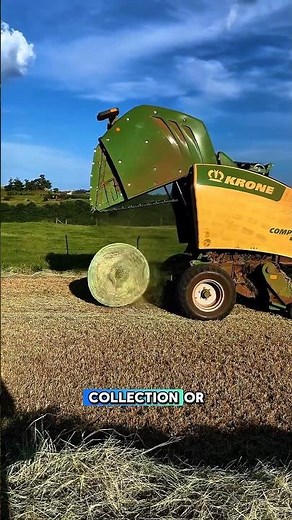 TRACTOR WITH HAY TEDDER IN FIELD OPERATION