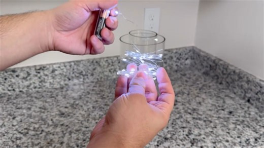 Stick string lights and a Dollar Store vase for this gorgeous countertop idea!