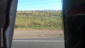 View from the bus window. View of the fields, trees, blue sky, the road through the curtains on the window of a moving bus. Concept relocation travel tourism transport transportation trip journey