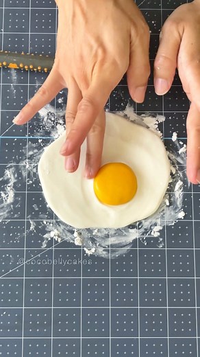 Huiwen on Instagram: "Made a chocolate fried egg for my avocado toast cake. Modeling chocolate, Sugar Shapers, ball tools, and a final slick of gloss are some of my MVPs for making hyper realistic cakes. I actually didn’t used a real fried egg as a model here because all my fried eggs turn out ugly. Modeling chocolate: @satin.ice Sugar Shapers: @sugarworksco #isitcake #cakedecorating #foodcake"