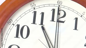 Close-up of a vintage clock face at 11 o'clock with a second hand moving
