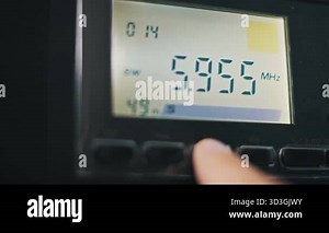 A finger presses buttons on a multi-band radio switching between MW SW LW and FM modes on the digital LCD display. The frequency numbers change as the receiver scans for a broadcast station Stock Video Footage - Alamy