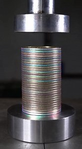 Watch a towering stack of U.S. dollar coins with stunning aurora-colored edges get slowly crushed by a hydraulic press. The coins dish and flatten as the press compresses them into a shorter stack with pure metallic pressure and satisfying ASMR sounds. | Nic Davis