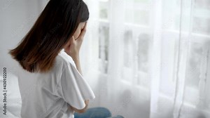 Psychologist touches a depressed Asian woman for encouragement. Woman crying and then friend's hand came to her shoulder to comfort and encourage.