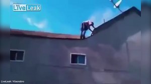 Shocking moment man backflips off two storey building