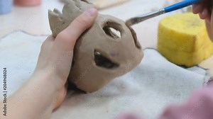 The child learns to mold different kinds of clay products in a ceramic workshop. The child works independently with clay in a lesson in a creative lesson. Stock Video