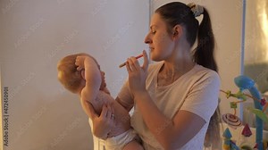 Young mother giving medicines to her baby son with syringe or eyedropper. Concept of children healthcare, healing, treatment and illness.