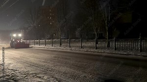 Snow Blowing Tractors Clearing Snow On The city Streets at winter in night