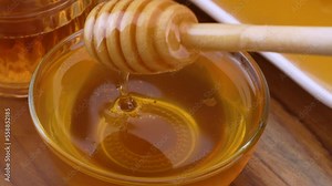 Close-up of Honey dripping from honey dipper in a bowl.