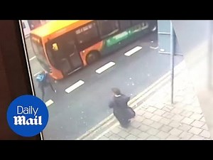 Shocking moment groggy cyclist stumbles into moving bus after falling off bike