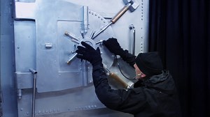A safecracker breaking into a bank vault | Premium Stock Video Footage