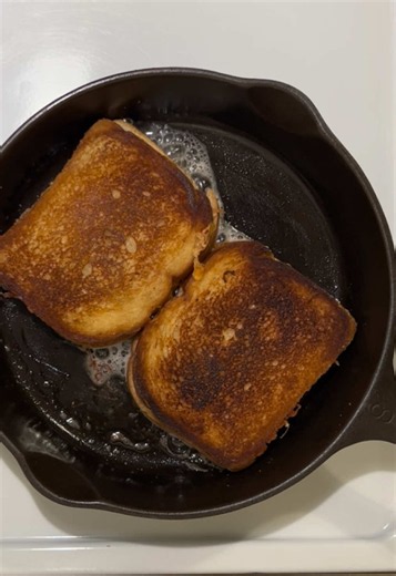 POV: I entered the kitchen for one grilled cheese and accidentally summoned a dairy-fueled spiritual awakening. Four innocent slices of bread went into the cast iron. They came out with the crunch of a thousand tiny applause breaks and enough melted cheese to solve at least three emotional problems. If you don’t hear the skillet sizzling, did you even make grilled cheese? #GrilledCheese #CastIronCooking #FoodTok #CheesePull #HomeCooking