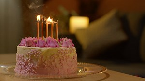 Free stock video - Candles being blown out on party celebration cake for birthday decorated with icing on table at home 1