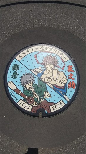 Manhole cover featuring Yahiko Myojin and Sanosuke Sagara from Rurouni Kenshin [Nagaoka City]