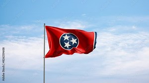Flag US state Tennessee against cloudy sky. Tennessee flag waving in the wind, national symbol. State, nation, union, flag, government, culture, politics.
