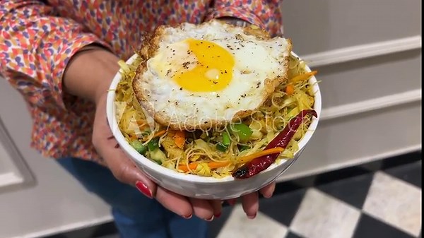 Singapore noodles with egg poach served by an Indian girl
