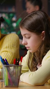 Vertical Video Diverse classmates scholars doing their class homework together in the library, working hard to obtain good grades. Focused schoolgirls solving their assignments with academic materials