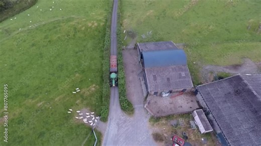 Machynlleth sheep farm in Wales with drone video moving over tractor driving.