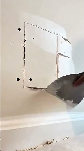 Applying joint compound smoothly over a drywall patch to create a seamless and professional surface