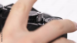 A close-up demonstration of a professional photographer taking pictures using old technology single-lens reflex camera. Choosing mode on camera mode deal. Isolated, on white background