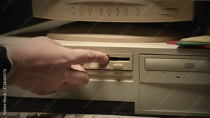 Using diskette FDD for old computer close-up. Hand inserting and ejecting Floppy Disk into vintage PC. Music recorder, playing retro computer games.