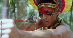 Indian from the Pataxó tribe using a bow and arrow. Brazilian Indian. 4K.