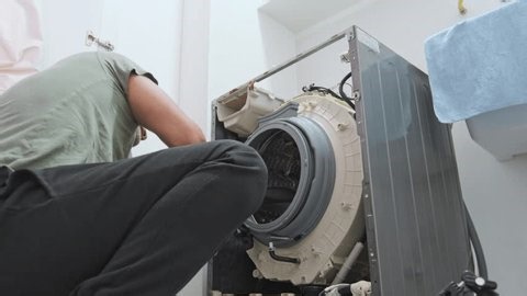 clip-3998827939-male-technician-fixing-malfunction-household-washing ...