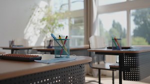 Rays of light falling to the empty dark classroom. the camera panning behind rows of desks and chairs. teaching class without students during a break. abandoned school. disturbing mood. Premium Stock Video Footage