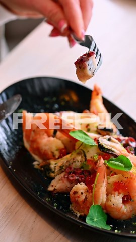 Close up of seafood salad on plate. Macro of shrimp and octopus seafood salad with herbs and sauce in restaurant setting | Premium Stock Video Footage