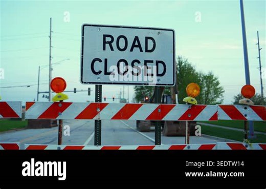 Blocked roadway with barricades and warning sign ROAD CLOSED at dusk showing restricted access and construction area. High quality 4k footage Stock Video Footage - Alamy