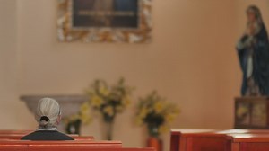 Elderly woman sitting on a pew in a church - Free Stock Video