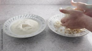 Preparing Homemade Arepa: Expert hands knead a corn mixture in a bowl, preparing traditional Colombian and Venezuelan arepas. A second bowl with ready-to-knead mixture sits nearby