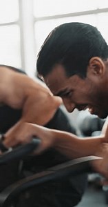 Exercise bike, cardio and men in gym, training and challenge with motivation, sweating and fitness. Breath, trainer and guys in wellness center, power and commitment with routine, cycling or workout