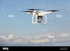 White remote controlled Drone Dji Phantom 3 equipped with high resolution video camera hovering in air and blue sky Stock Photo - Alamy