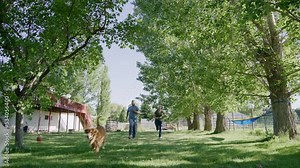 Man and woman training their dogs at barnyard of a countryside cottage. Adventurous lifestyle in tranquil rural area. High quality 4k footage