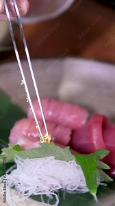 Decorate pieces of raw fish with edible gold. Raw fish served in a restaurant