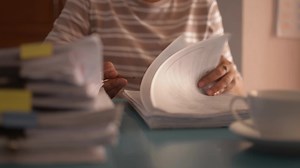 Download Female teacher examining the student's test on working the desk. for free