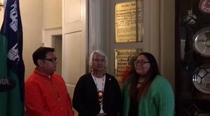 Brad Joe, Lillie Roberts and Miss Choctaw Nation Karen Crosby sing Hymn 48 near the plaque in Lord Mayor's house commemorating the $170 sent to Ireland in 1847. | Choctaw Nation of Oklahoma