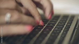 Fingers typing text on keyboard.