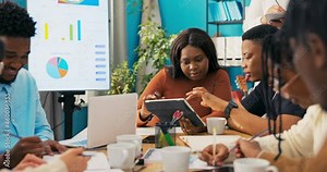 Employees show the manager on the tablet a new advertisement, a spot of the company's services, the boss marks tasks on the calendar, evaluates the effects of their work, writes down notes