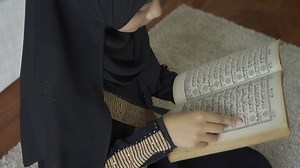 An Asian Muslim woman reciting Salah or Salat al-Fatiha passage of the Qur'an, in a single act of sujud called a sajdah or prostrations at home | Premium Stock Video Footage
