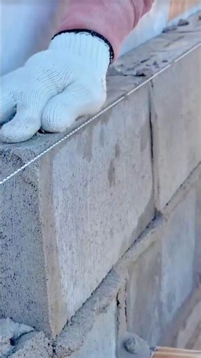 Mason aligning stone blocks precisely using taut guide string